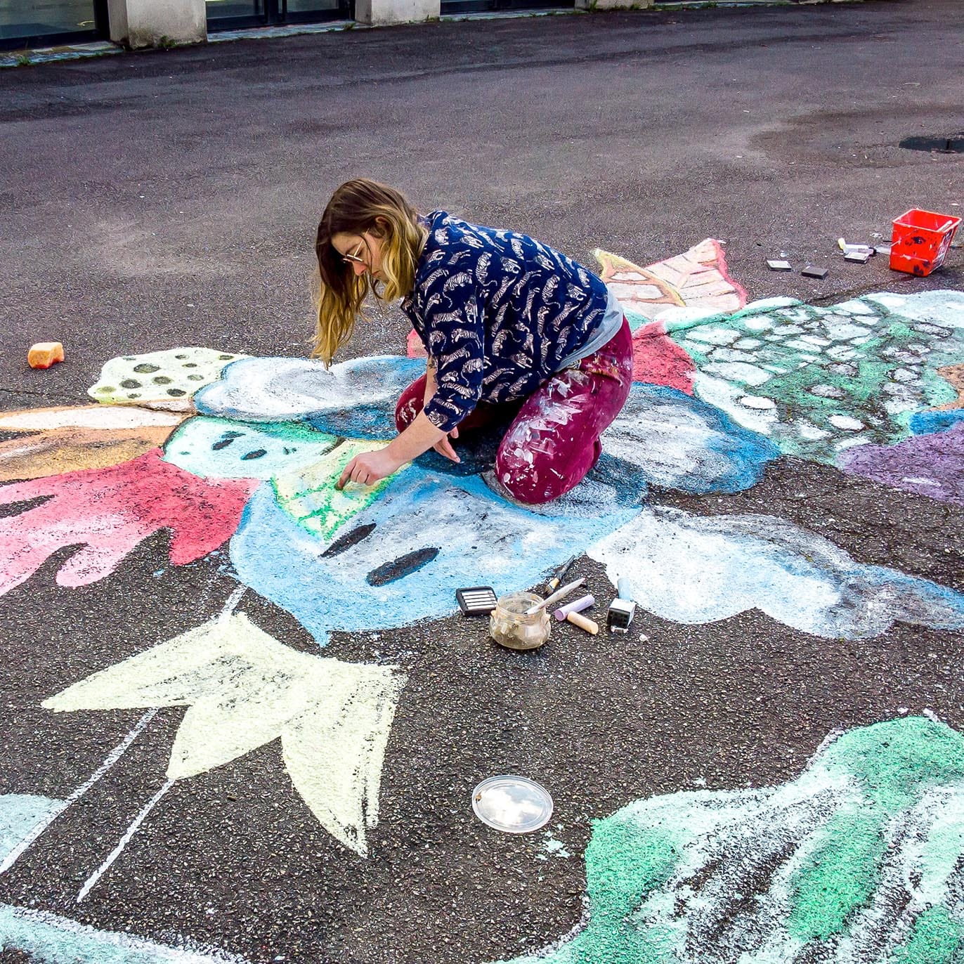 Vue rapprochée de l'artiste peintre Tsuki dans la Lune en train de dessiner à la craie au sol